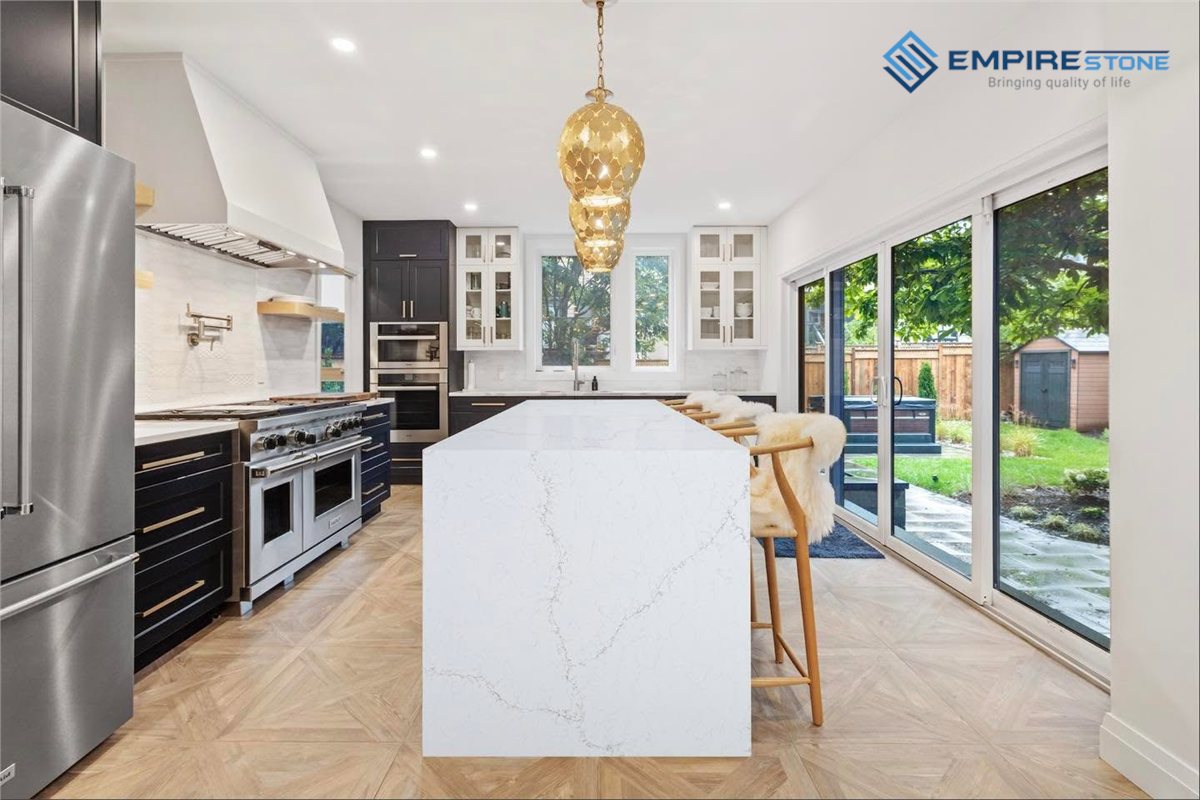 Đá ốp bếp phong cách Bắc Âu: Chọn màu, vân và cách phối với gỗ sáng Đảo bếp ốp đá trắng vân xám kiểu thác nước trên sàn gỗ lát xương cá