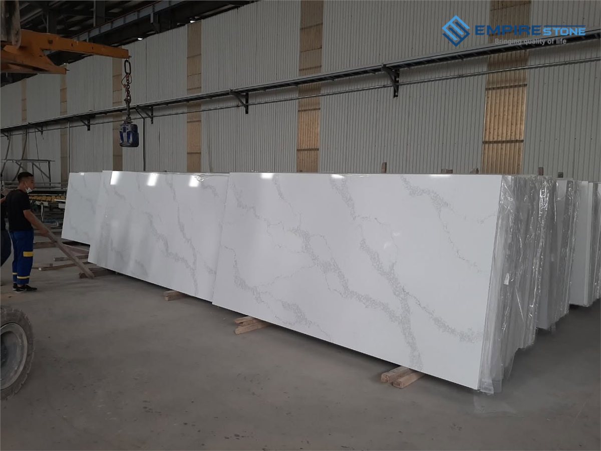 Các tấm đá nhân tạo nền trắng vân xám khổ dài đang được cẩu trong nhà xưởng