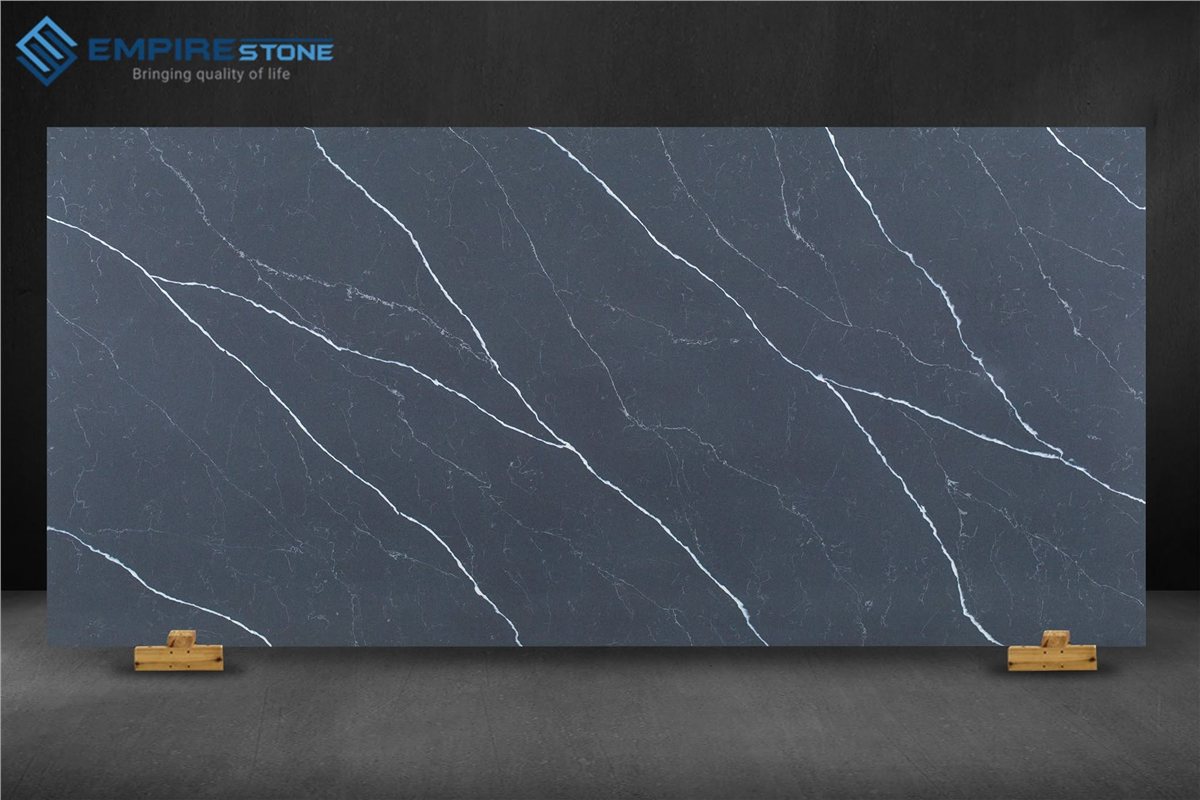 Đá nhân tạo vân marble Calacatta: Phân biệt với Carrara, Statuario và cách chọn vân phù hợp Tấm đá nhân tạo nền xám than vân trắng chạy chéo trưng bày trên nền tối